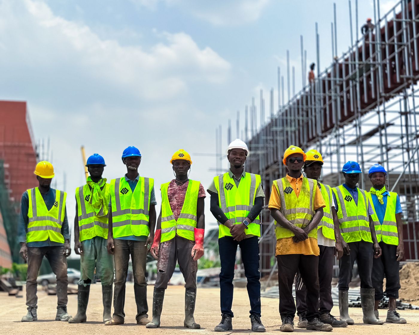 Une grande équipe en gilet devant un chantier
